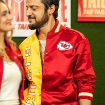Person wearing a red and yellow sports jacket with a logo in an indoor setting.