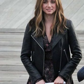 Woman wearing a black leather jacket over a floral dress, standing on a staircase.